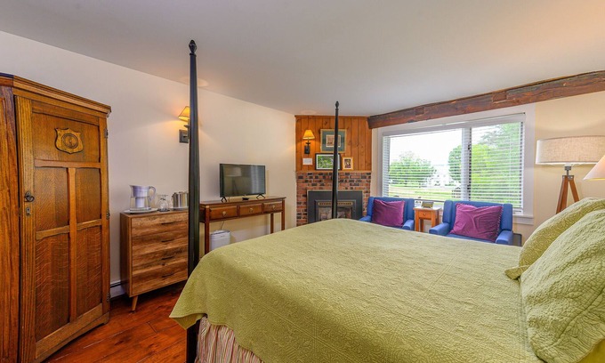 Stowe Bed & Breakfast | Comfortable, pet friendly room with queen bed, a stunning view of Mount Mansfield, sitting area and a fireplace with full service breakfast included